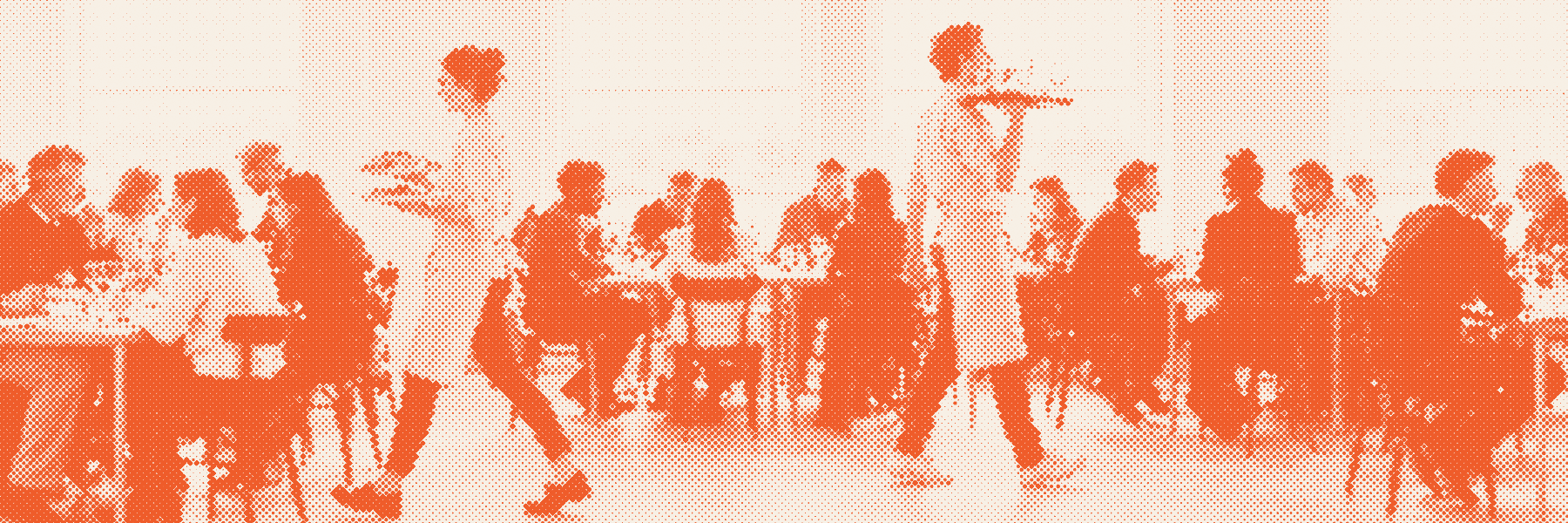 Een volle lunchservice: bediening loopt met borden en dienbladen tussen de bezette tafels door.